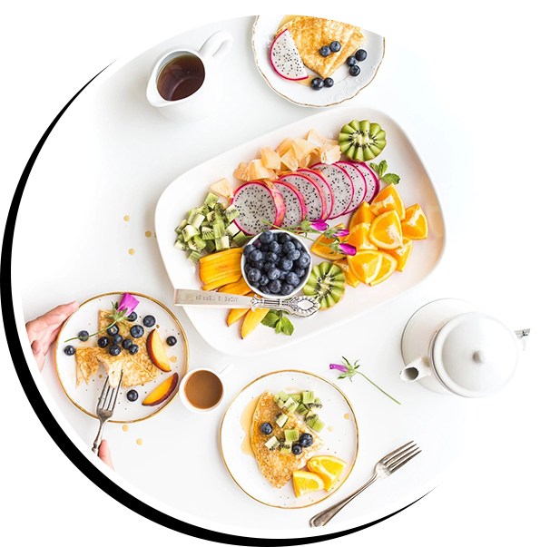 A white table topped with plates of food.